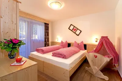a bedroom with two beds and a table and a window at Stiflerhof in Falzes