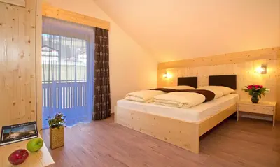 a bedroom with a bed and a large window at Stiflerhof in Falzes