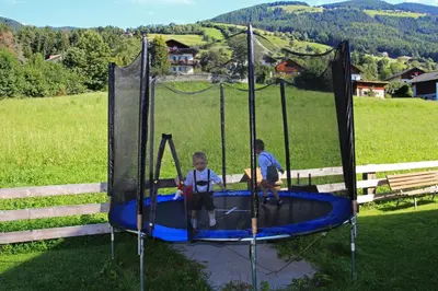 two young boys playing on a trampoline at Stiflerhof in Falzes