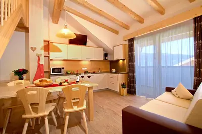a kitchen and living room with a table and chairs at Stiflerhof in Falzes