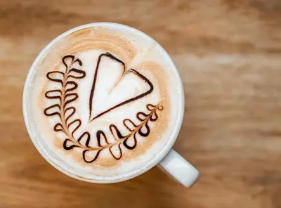 a cup of coffee with a heart drawn on it at Hotel Onach in San Lorenzo di Sebato