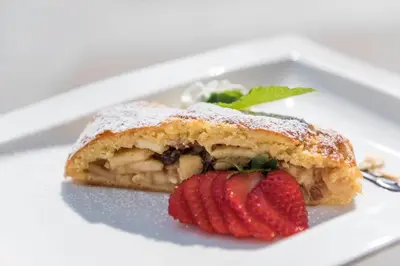 a piece of pastry with a strawberry on a plate at Hotel Onach in San Lorenzo di Sebato
