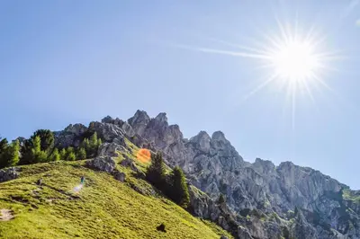 a sun shines on a hill with a mountain at Hotel Onach in San Lorenzo di Sebato