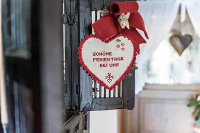 a heart shaped sign hanging on a wall at Hotel Onach in San Lorenzo di Sebato