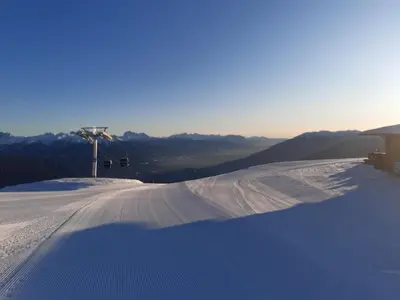 a snow covered ski slope with a ski lift at Pitznerhof in Maranza
