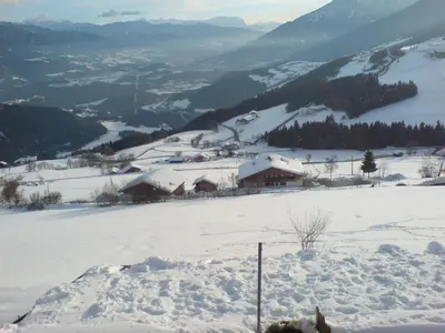 a snow covered mountain with a lodge in the distance at Pitznerhof in Maranza