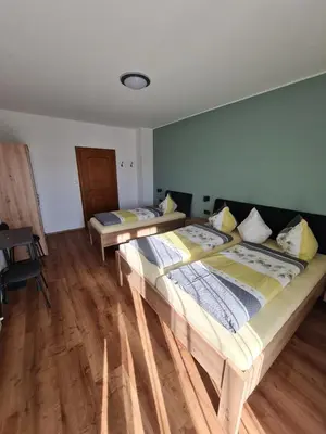 two beds in a room with wooden floors at Gasserhof Bozen in Bolzano