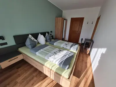 a large bed in a room with wooden floors at Gasserhof Bozen in Bolzano