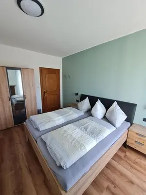a large bed with white sheets and white pillows at Gasserhof Bozen in Bolzano