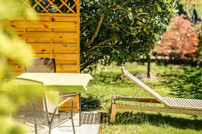 a table and chairs in the grass next to a building at Appartements Residence Ganthaler in Rablà