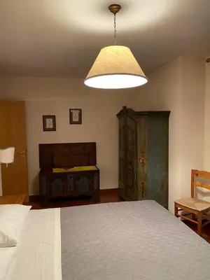 a bedroom with a large bed and a lamp at CASA DI PITTO in Bressanone