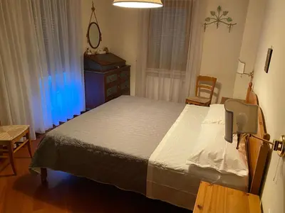a bedroom with a bed and a chair and a window at CASA DI PITTO in Bressanone