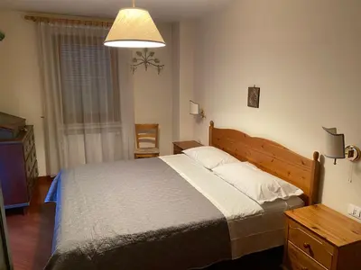 a bedroom with a large bed and a lamp at CASA DI PITTO in Bressanone