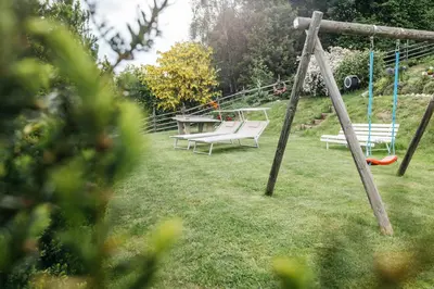 two swings and a table in a yard at Lisis Loggia in Nova Ponente