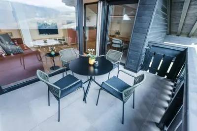 a balcony with a table and chairs and a couch at Lisis Loggia in Nova Ponente
