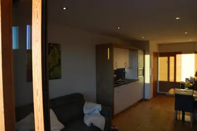 a living room with a couch and a kitchen at Lobishof in Soprabolzano