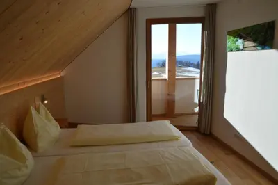 a bedroom with a bed and a large window at Lobishof in Soprabolzano