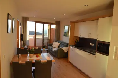 a kitchen and a living room with a table at Lobishof in Soprabolzano