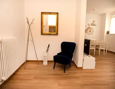 a living room with a chair and a mirror at Portico ventizerodue in Merano