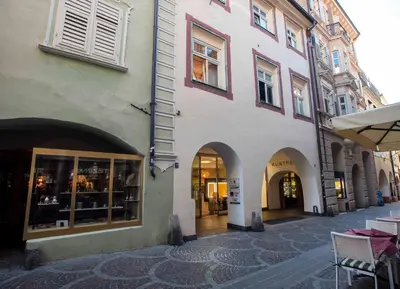 a building with arches and tables in a street at Portico ventizerodue in Merano