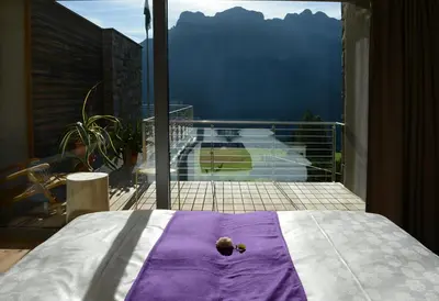 a bed with a purple and white blanket on a balcony at Fior Tamion in Vigo di Fassa
