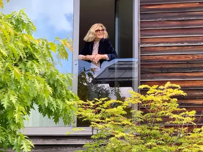 a woman sitting in the window of a house at Fior Tamion in Vigo di Fassa
