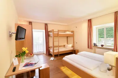 a bedroom with a bed and a desk and a bunk bed at Ansitz Gamp in Chiusa