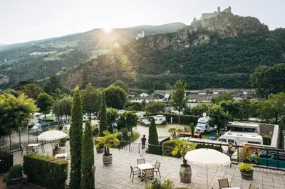 a person standing in a park with a mountain in the background at Ansitz Gamp in Chiusa