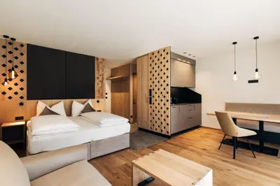 a bedroom with a bed and a desk in a room at Ansitz Gamp in Chiusa