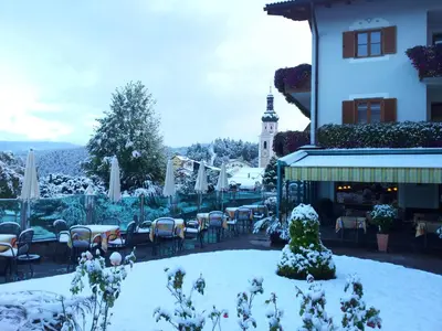a restaurant covered in snow in front of a building at Hotel Garni Doris in Castelrotto
