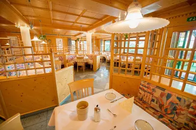 a restaurant with wooden walls and tables and chairs at Hotel Garni Doris in Castelrotto