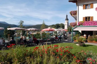 a group of people sitting at a restaurant with a clock tower at Hotel Garni Doris in Castelrotto