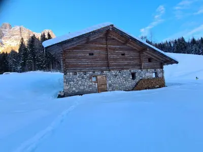 a log cabin with snow on the ground at Baita Pra Petina Pale di San Martino in Siror