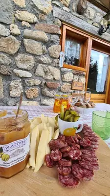 a table with cheese and meat and a jar of honey at Baita Pra Petina Pale di San Martino in Siror