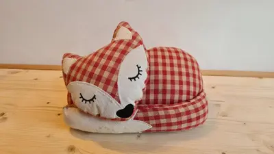 a stuffed animal in a red checkered bag on a table at Baita Pra Petina Pale di San Martino in Siror