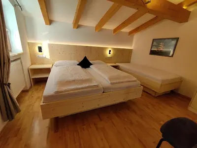 a bedroom with two beds in a room with wooden floors at Residence Klementhof 4 in Fiumes