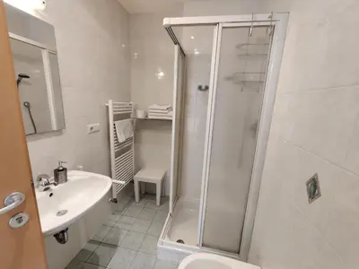 a bathroom with a shower and a toilet and a sink at Residence Klementhof 4 in Fiumes
