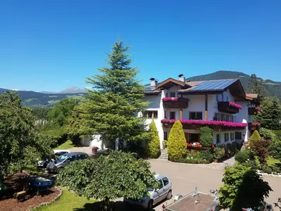 a large house with cars parked in a parking lot at Residence Klementhof 4 in Fiumes