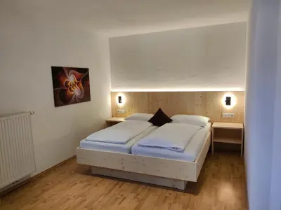 a bedroom with a white bed and two night stands at Residence Klementhof 4 in Fiumes