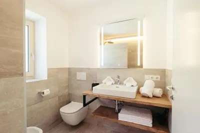 a bathroom with a sink and a toilet and a mirror at Villa Bea in Caines