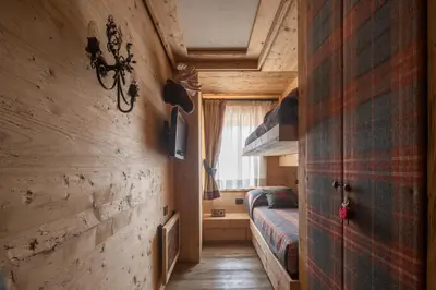 a small bedroom with a bed and a window at Cortina Deluxe Chalet R&R in Zuel