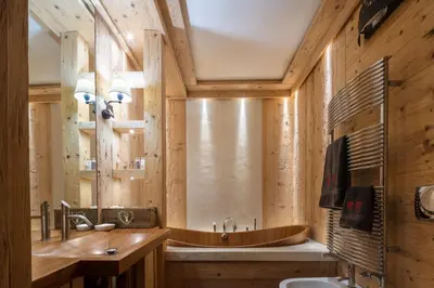 a wooden bathroom with a tub and a sink at Cortina Deluxe Chalet R&R in Zuel