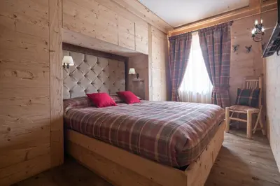 a bedroom with a large bed with red pillows at Cortina Deluxe Chalet R&R in Zuel