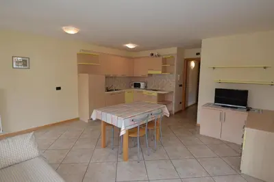 a kitchen with a table and a kitchen with a couch at Casa Fior del Soreie in Pozza di Fassa