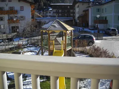 a playground with a slide in the snow at Casa Fior del Soreie in Pozza di Fassa