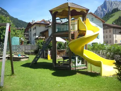 a playground with a slide and a gazebo at Casa Fior del Soreie in Pozza di Fassa