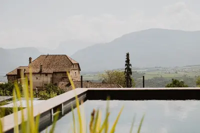 an old house with a mountain in the background at Ansitz Montani Eppan in Appiano sulla Strada del Vino