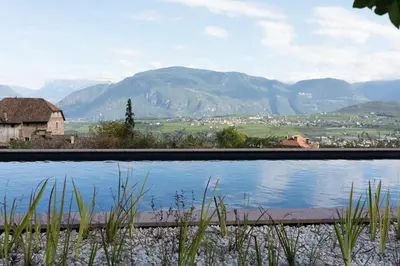 a swimming pool with a view of mountains at Ansitz Montani Eppan in Appiano sulla Strada del Vino