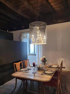 a dining room with a wooden table and a chandelier at Ansitz Montani Eppan in Appiano sulla Strada del Vino
