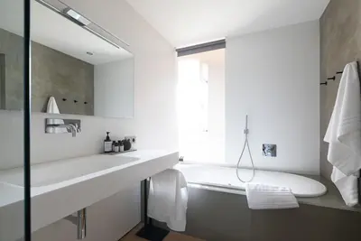 a white bathroom with a tub and a sink at Ansitz Montani Eppan in Appiano sulla Strada del Vino